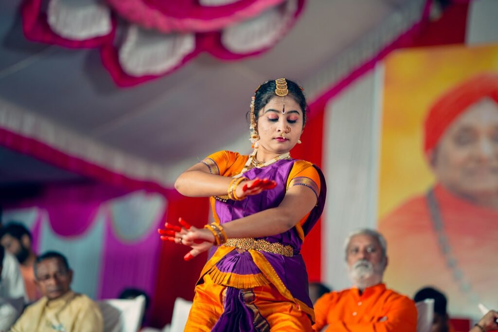 A woman in an orange and purple outfit dancing