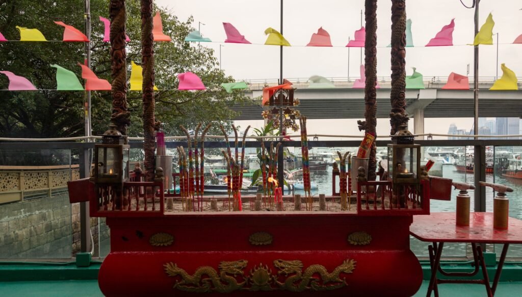 Incense burner with colorful flags in background.