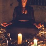 woman in black long sleeve shirt sitting on chair in front of candles